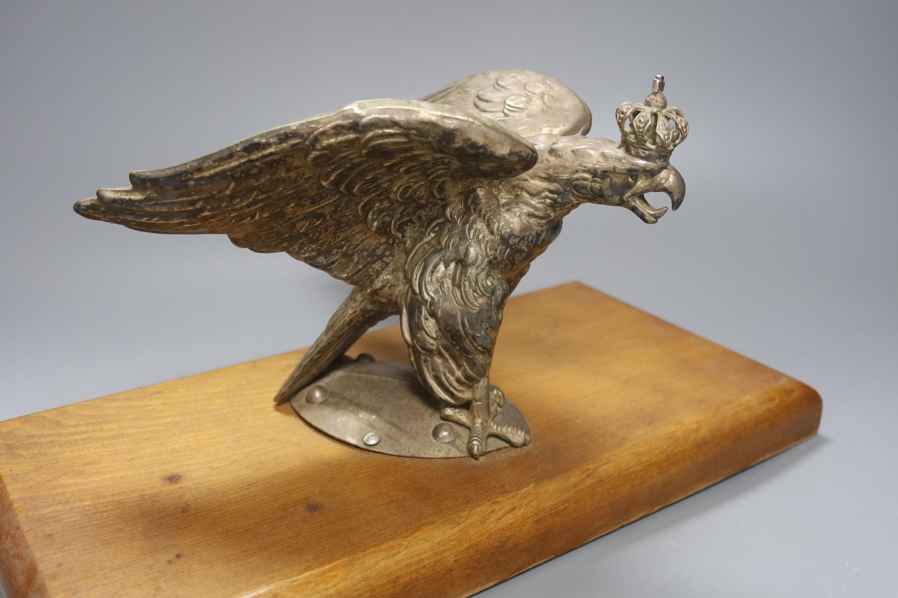 A plated Prussian eagle finial for a Prussian Guard’s helmet, later wood plinth, W36cm